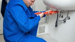 Monteur mit Heitkörper. Energie sparen. Ablesen der Heiungs - Einstellung.