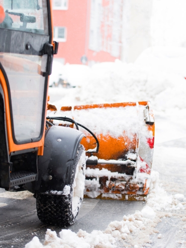 Schneepflug räumt die Straßen in der Stadt, Winterdienst